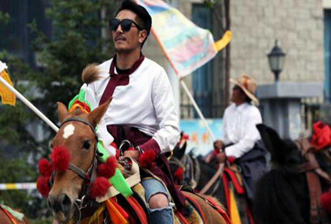 图为一名时髦装束的康巴少年骑马巡演。